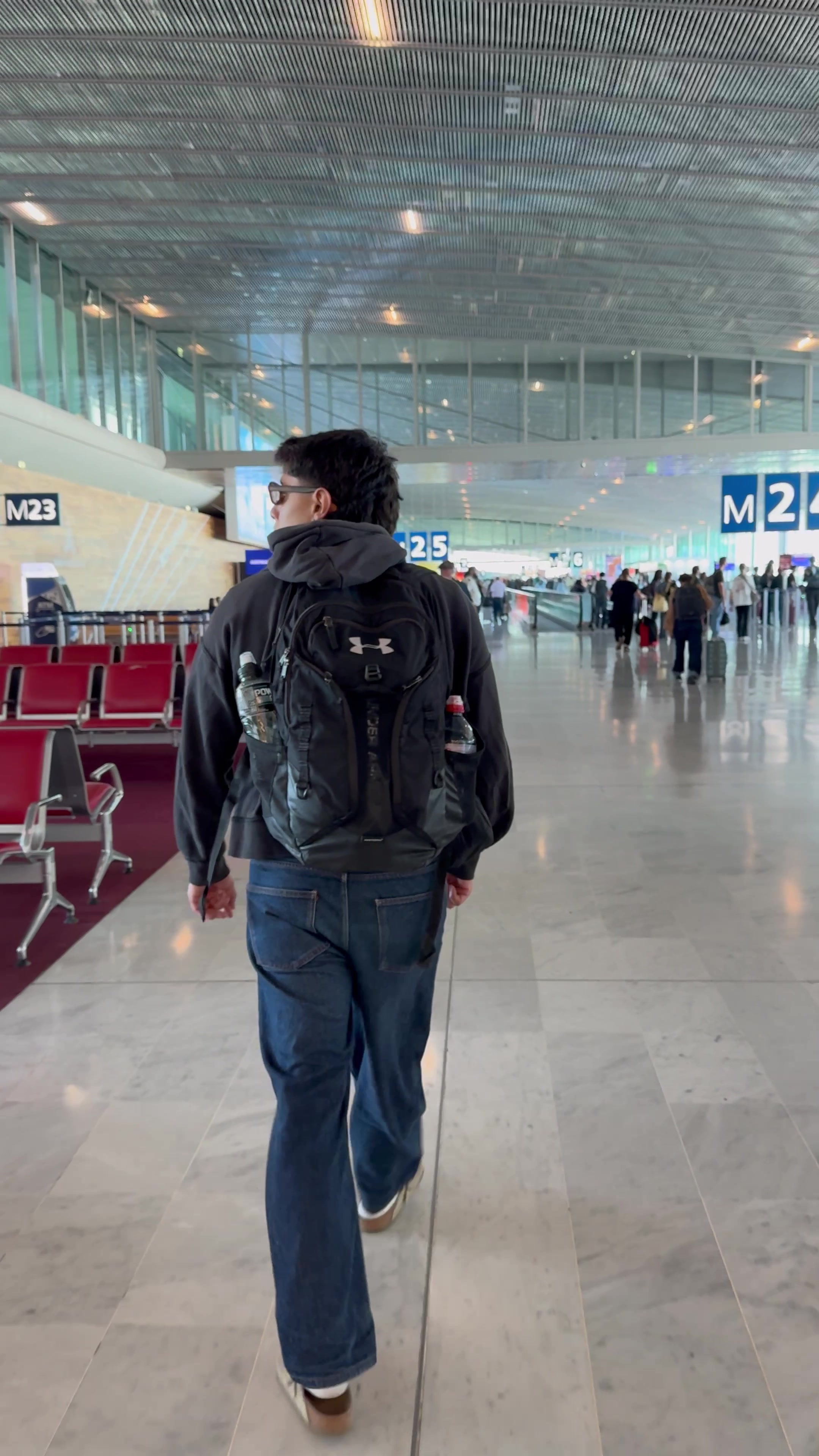 Man Walking Through Airport Concourse