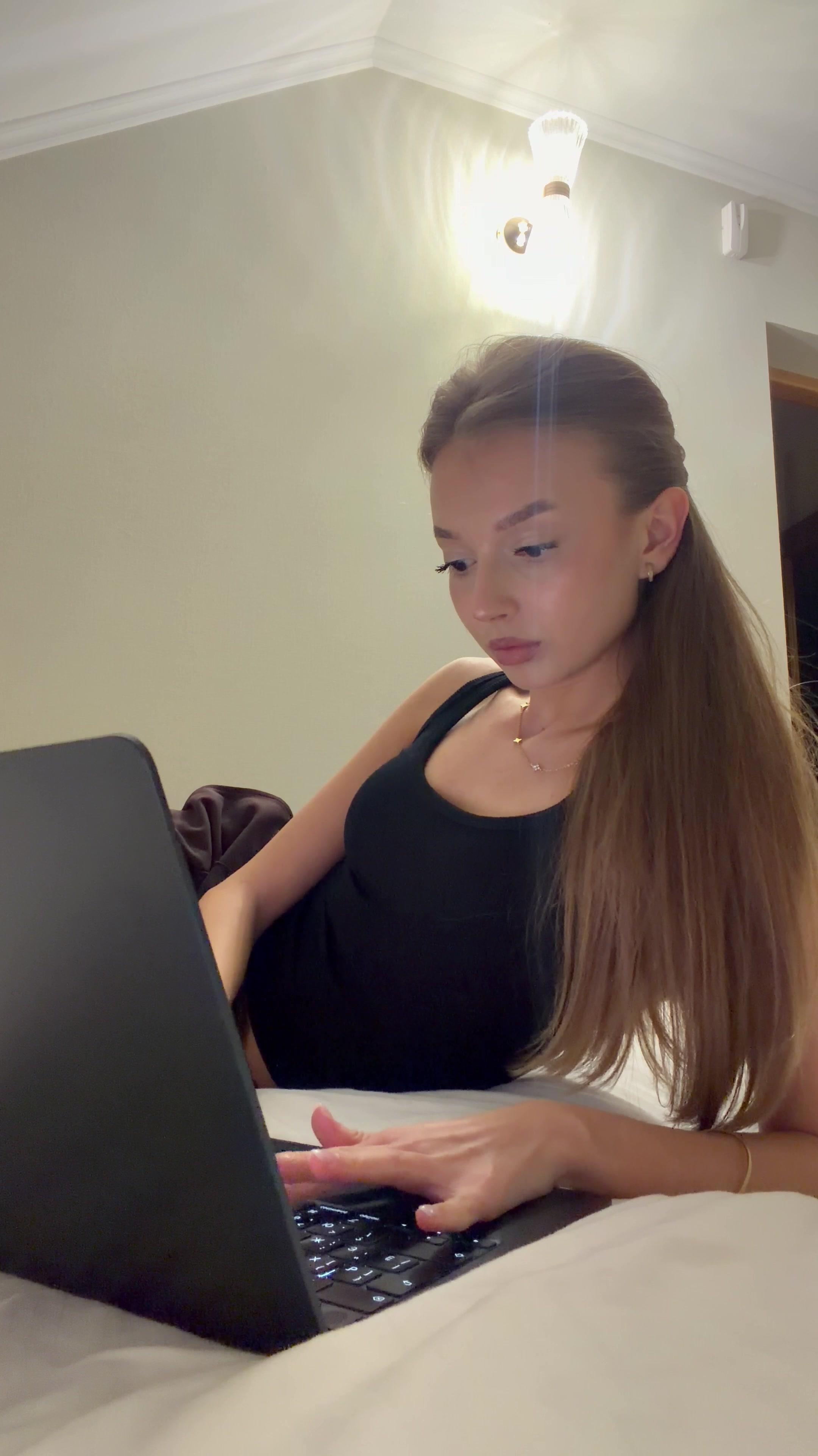 Woman Typing on Laptop in Bed