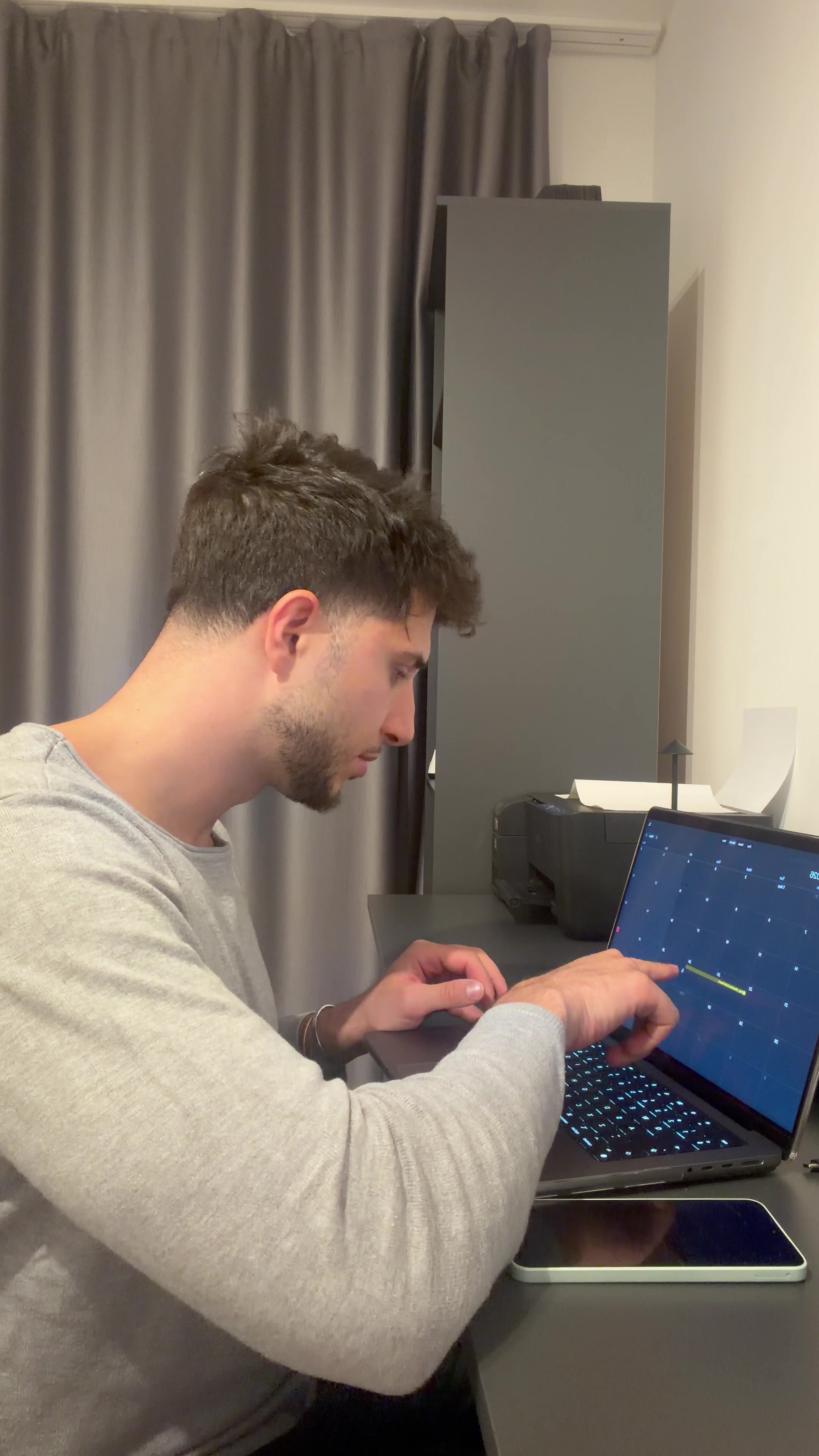 Young Man Checking Laptop and Making Phone Call