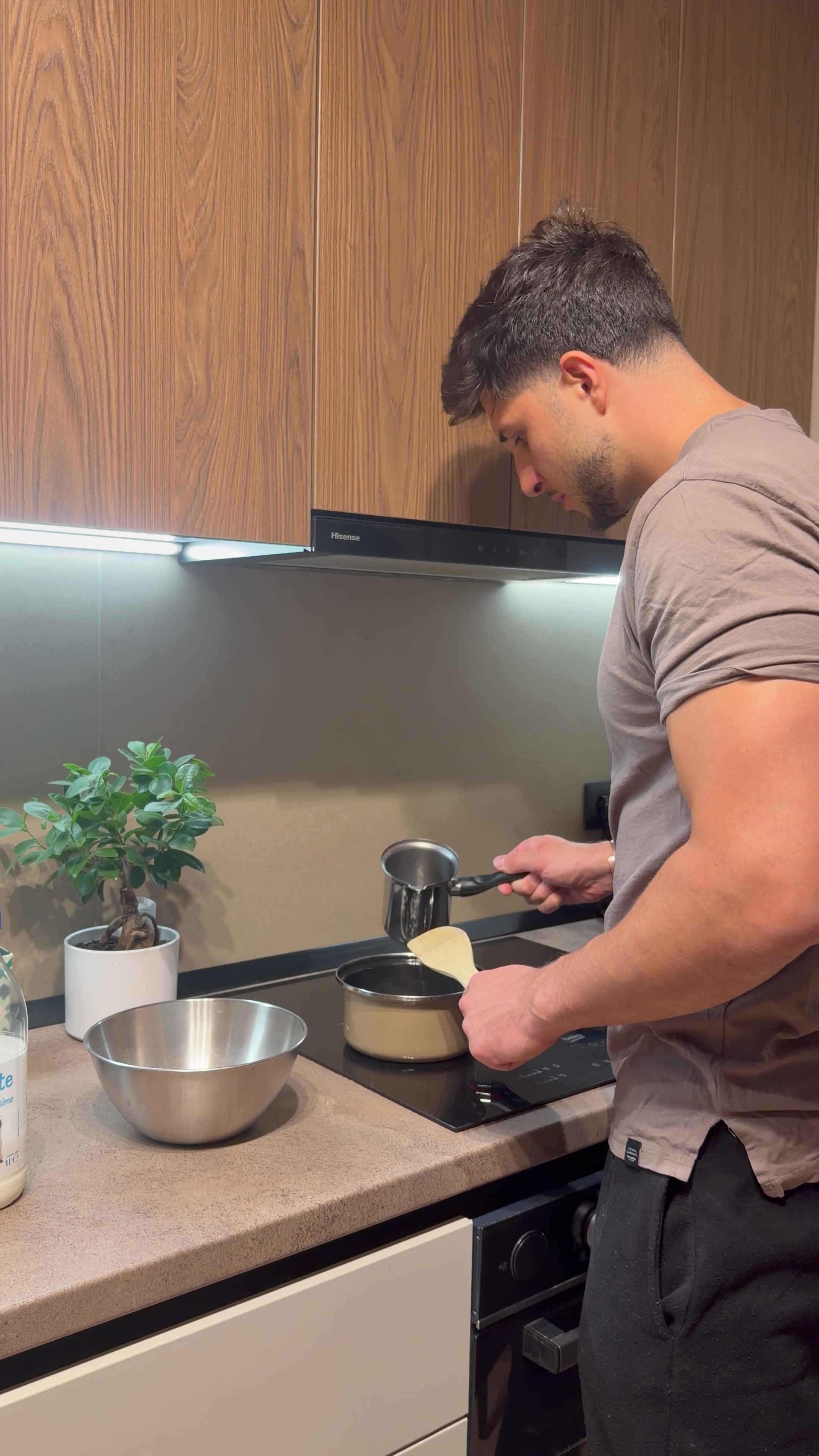 Young Man Cooking Oatmeal in Kitchen
