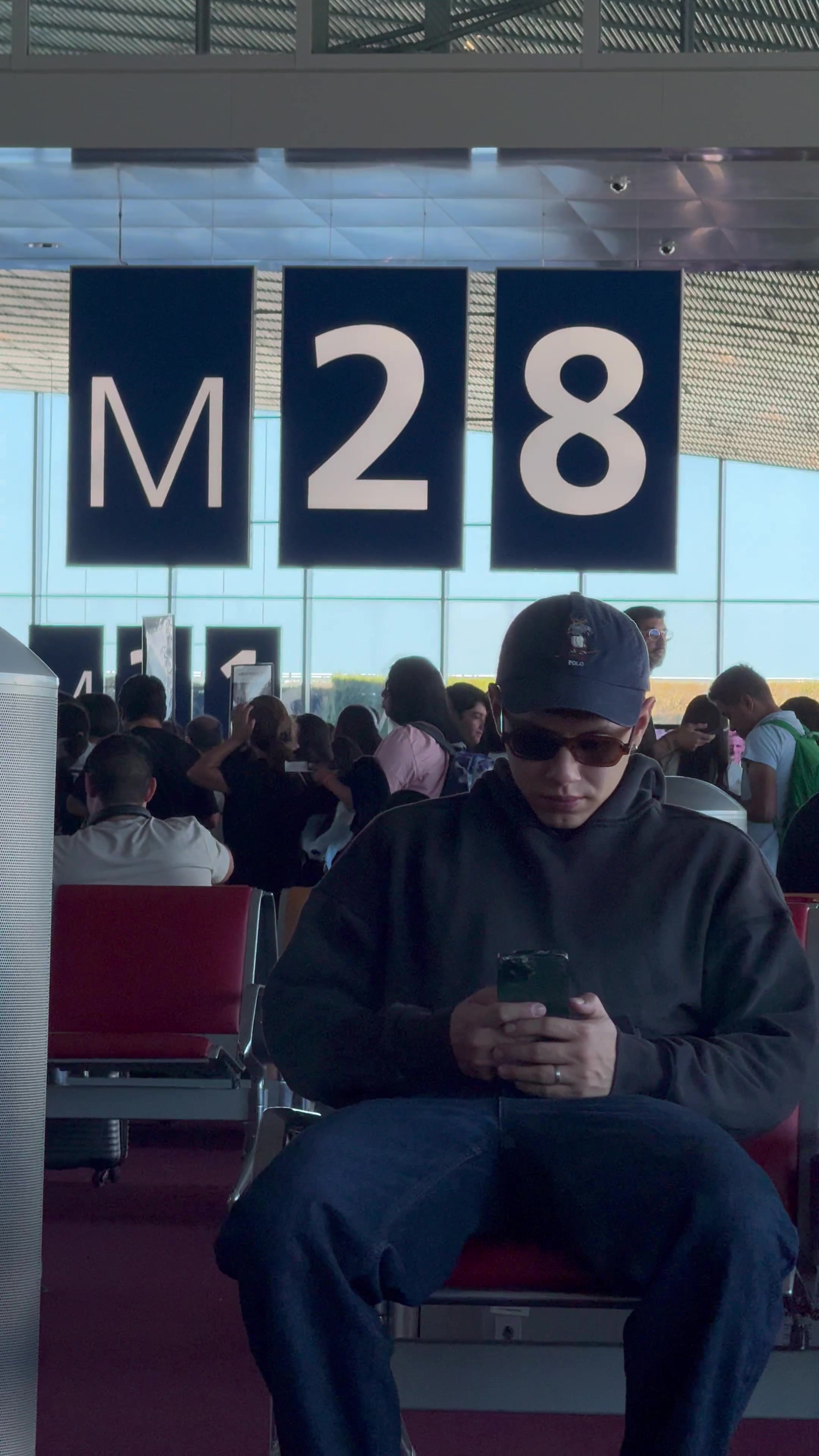 Man Checking Phone at Airport Gate