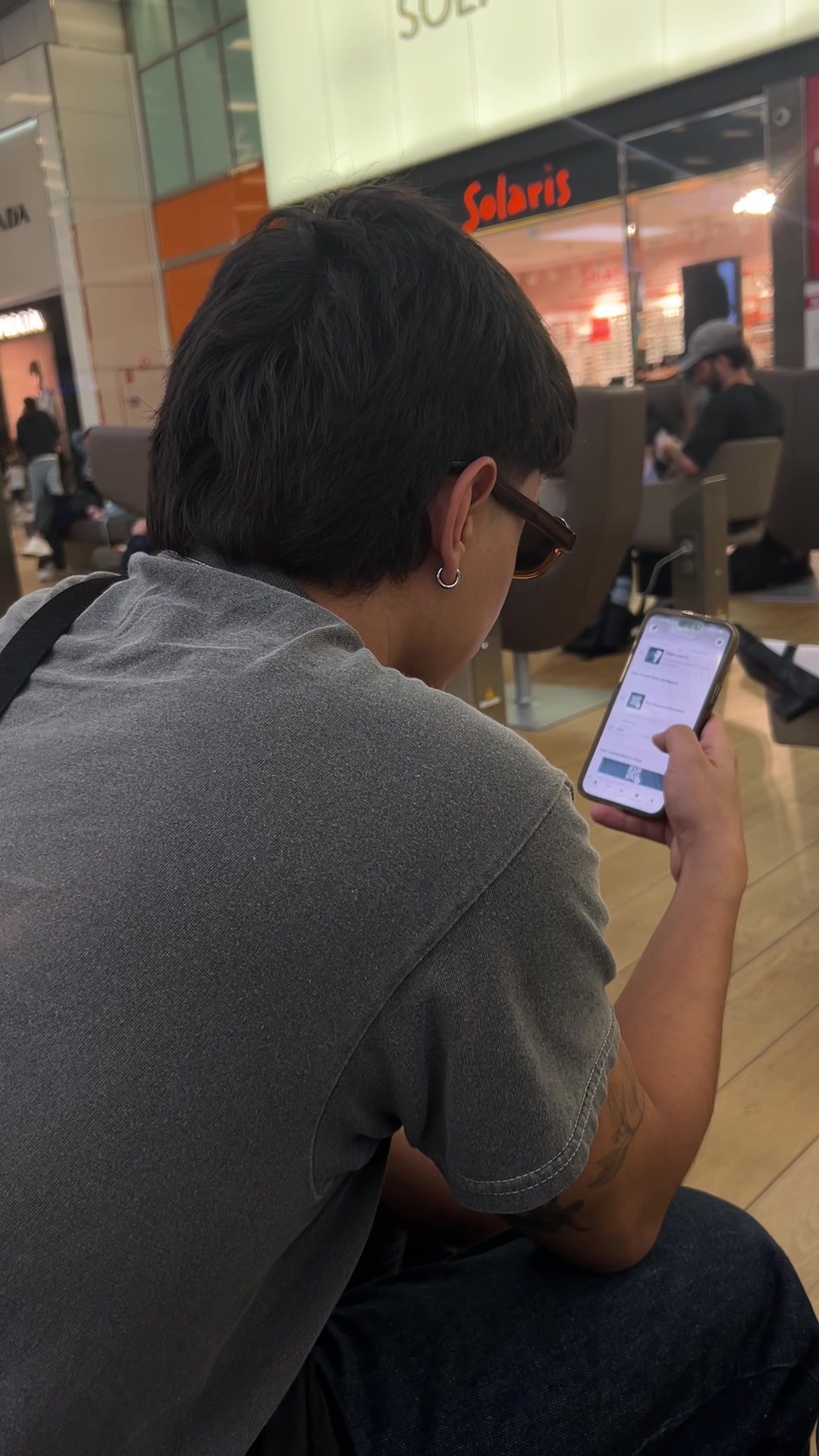 Man Browsing Phone in Waiting Area