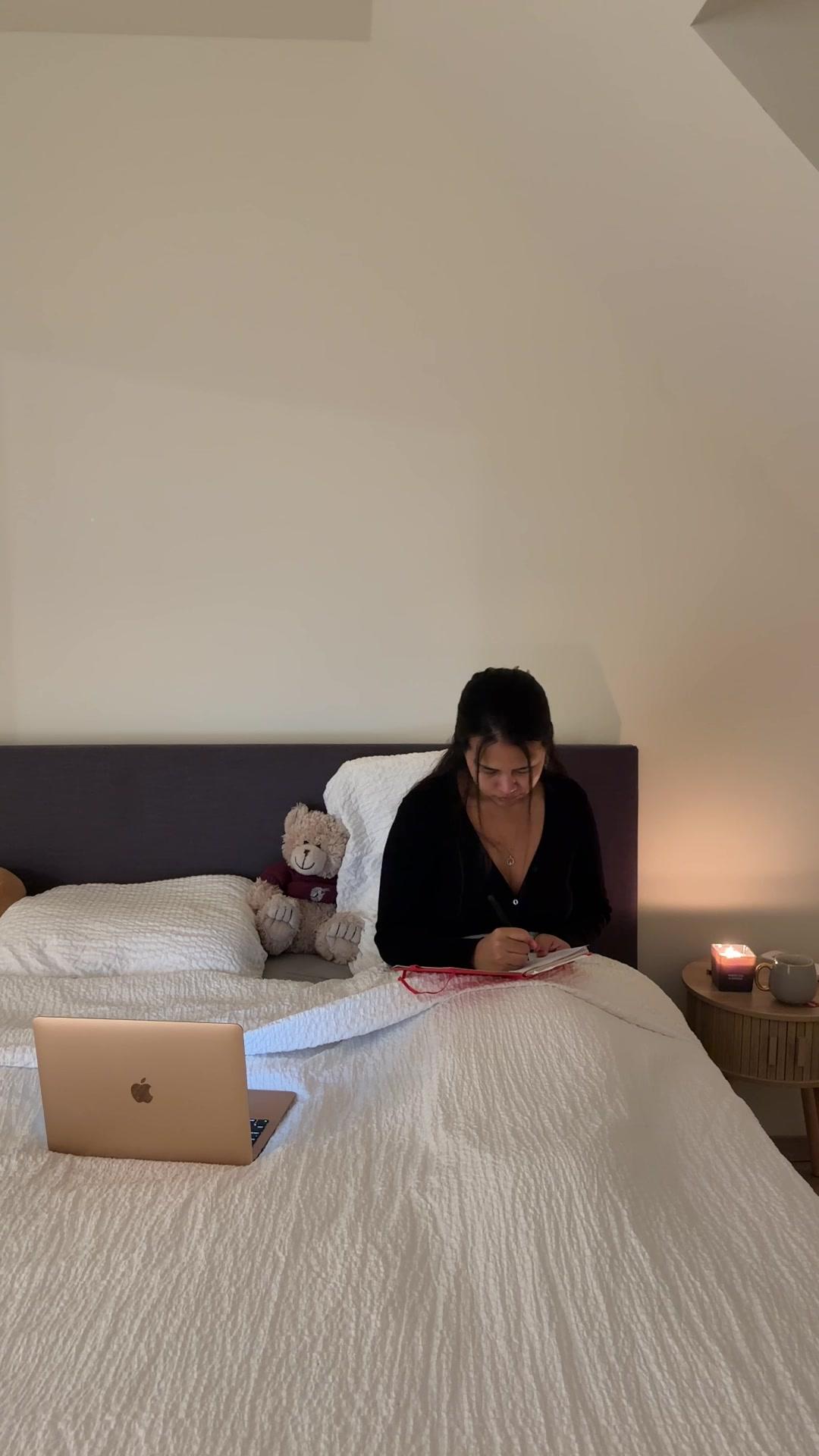 Woman Writing in Notebook on Bed